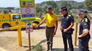 Agents de la Policia local de Palamós i ADF, davant la tanca del camí d'accés a cala Estreta i la platja de Castell (Arxiu)