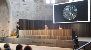 L'investigadora Anna Sànchez durant la lliçó inaugural de la UdG amb el rector, Quim Salvi, escoltant-la