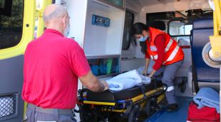 Dos treballadors de TSC preparant una ambulància per traslladar un pacient