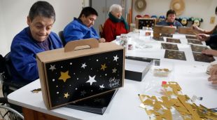 Usuaris de la Fundació MAP durant el taller de fer caixes de panera de Nadal