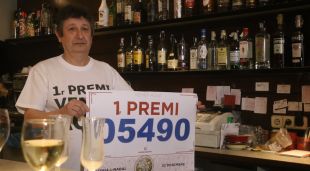 El propietari de l'administració de Platja d'Aro mostrant el dècim premiat amb la grossa de Nadal