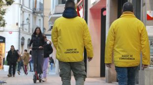 Dos agents de convivència amb una noia amb patinet al fons
