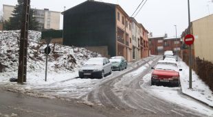 Diversos cotxes coberts de neu en un carrer de Sant Hilari Sacalm