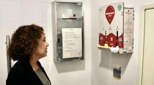 La delegada del Govern a Girona, Laia Cañigueral, davant un dels dispensadors de productes d'higiene femenina