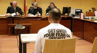D'esquenes, l'acusat de violar una noia de 16 anys a Sant Feliu de Guíxols. Foto del judici a l'Audiència de Girona