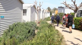 Diversos turistes caminen cap a la seva parcel·la d'un càmping de Roses
