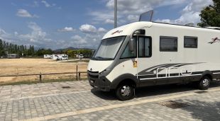 Una autocaravana aparcada a la zona habilitada al barri de Domeny de Girona amb diversos vehicles al darrera