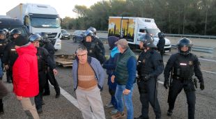 Els agents de la Brigada Mòbil fent marxar els pagesos que havien tallat l'AP-7 a l'altura de Borrassà