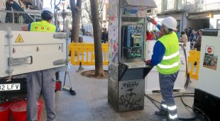 Els operaris retirant l'última cabina de telèfons que hi havia a Girona, al final de la Rambla