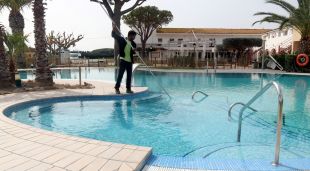 Un treballador netejant la piscina del càmping Les Medes de l'Estartit