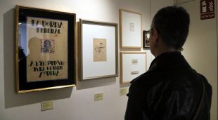 Una persona observant els dibuixos de l'exposició de Dalí