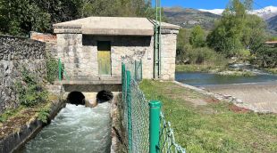 El canal que abasteix d'aigua la central de Llanars i el riu Ter a l'altre costat amb les muntanyes nevades