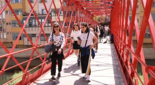 Visitants travessant el pont de les peixetaries velles a Girona l'últim dia de Temps de Flors