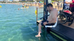 Un banyista amb mobilitat reduïda fent us del sistema