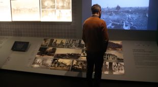Un home mira algunes de les fotografies exposades a 'A cor obert' del museu del cinema de Girona