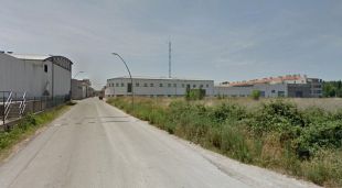 En primer terme els terrenys on anirà l'equipament i al fons les naus que seran enderrocades