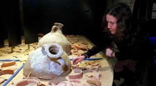 La comissària de l'exposició i responsable del CASC, Rut Geli, al costat d'un dels àmbits que recrea un enfonsament