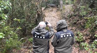Dos agents rurals, fent fotografies d'una estructura creada sense permís a les Gavarres per fer salts amb bicicleta