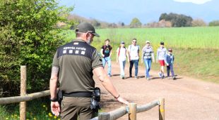 Un agent rural a l'entrada del volcà Cruscat amb uns visitants que arriben