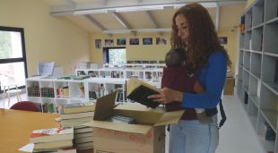 Imma Páez obre una caixa de llibres donats