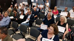 Els marxants protestant amb cartells durant el ple de Platja d'Aro on s'ha aprovat el nou reglament del mercat municipal
