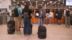 Persones esperant per utilitzar una màquina de venda de bitllets a l'estació de Sants