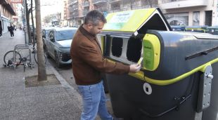 El regidor d'Acció Climàtica de Girona, Sergi Cot, obre un contenidor d'envasos amb una de les targetes