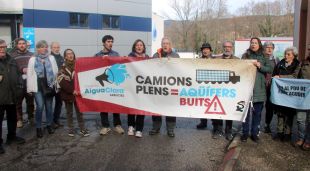 Representants dels ajuntaments que han subscrit la moció i entitats ecologistes protestant davant una planta embotelladora d'Arbúcies