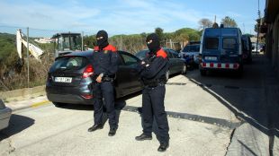 Dos mossos tapats amb passamuntanyes, aquest migdia al costat del descampat © ACN