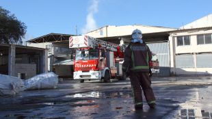 Bombers treballant en l'incendi de la nau en desús ubicada entre Blanes i Tordera © ACN