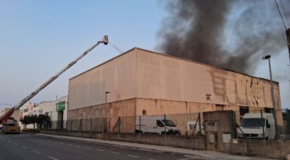 Els Bombers continuen remullant la nau industrial de Vilamalla afectada per l'incendi de dimarts