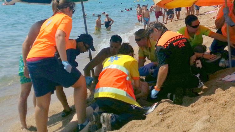 Els cossos d'emergència reanimant la víctima a peu de platja