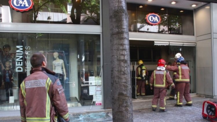 Els Bombers ventilant aquest matí l'interior de la botiga de roba © ACN