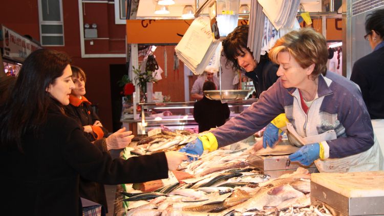 Una clienta comprant peix en una peixateria de Girona