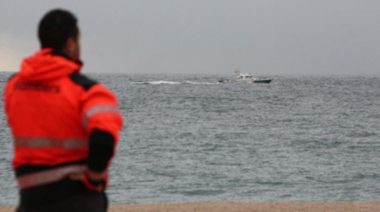 Un bomber a la platja de Tossa de Mar seguint el dispositiu de rescat © ACN