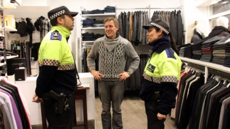 Un agent de la Policia Municipal de Girona i una agent cívic amb un comerciant © ACN