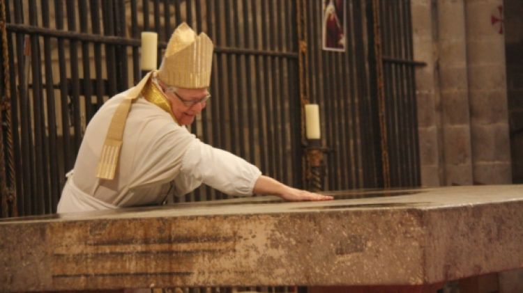 El bisbe de Girona, Francesc Pardo, espargint l'oli sant per sobre de l'altar major per consagrar-lo © ACN