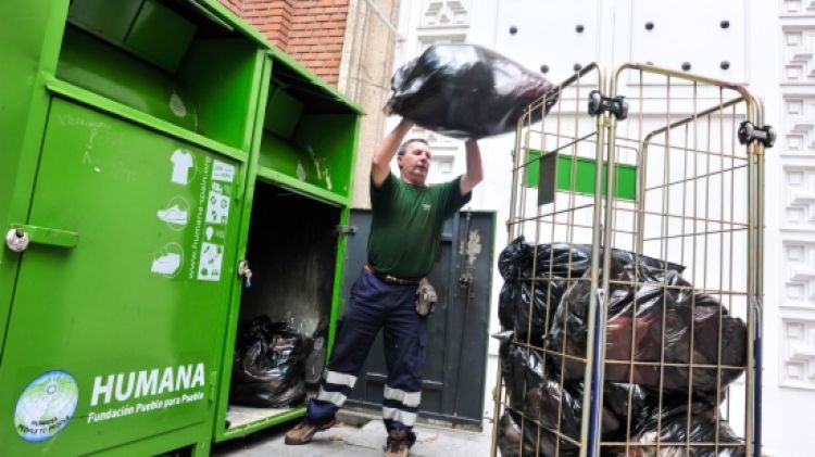 Un operari recollint roba dels contenidors © ACN