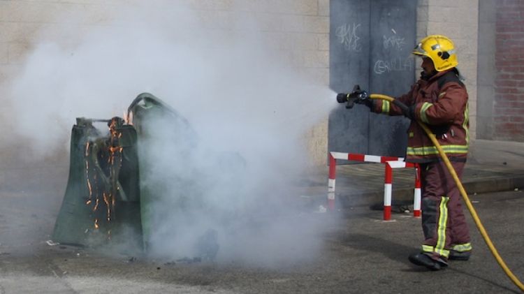 Un bomber apagant un dels contenidors afectats © AG