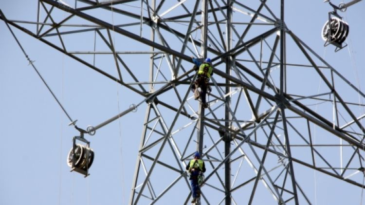 Operaris dalt una de les torres de la MAT © ACN