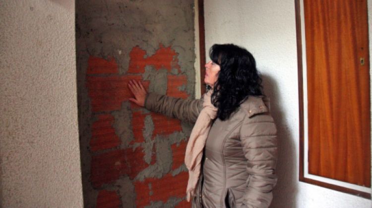 Una membre de la PAH Girona-Salt mirant un dels pisos que fa mesos que es manté tapiat al bloc © ACN