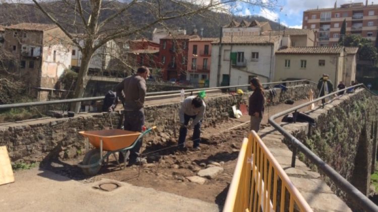 Operaris amb els treballs de restauració del pont medieval de Sant Joan les Fonts