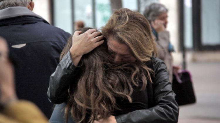 Una mare i la seva filla s'abracen a la sortida de l'institut Joan Fuster de Barcelona © ACN