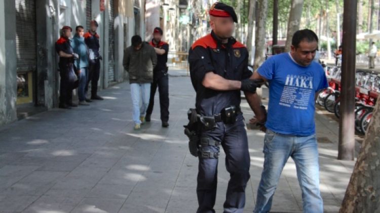 Els Mossos s'enduen els dos detinguts practicats en aquest habitatge de la rambla del Raval © ACN