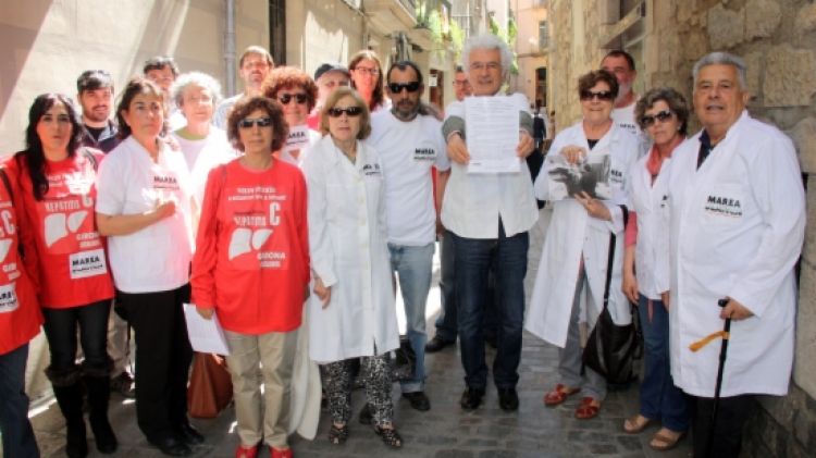 La vintena de membres de la Marea Blanca, aquest migdia a Girona amb el manifest © ACN
