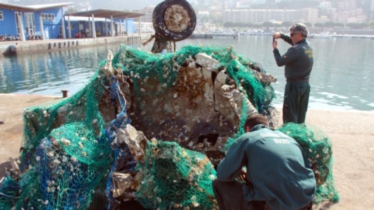 Agents de la Guàrdia Civil inspeccionant les restes de l'avió al port de Roses © ACN