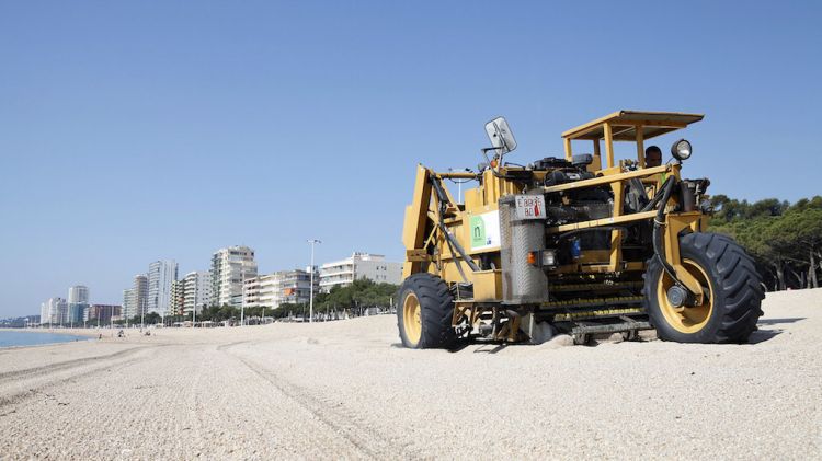 Una màquina netejant la sorra de la platja