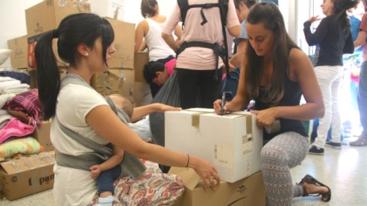 Dues voluntàries empaquetant el material que recullen des del local de Salt © ACN