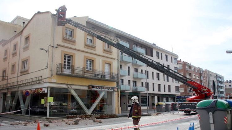 Els Bombers fent caure les parts de la façana que han quedat mig despreses de l'edifici © ACN