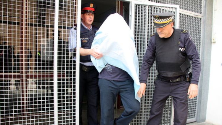 El detingut, sortint completament tapat dels jutjats de Santa Coloma de Farners © ACN